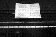 black upright piano with sheet music